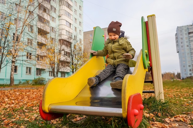 Full length of boy sitting on slide at playground