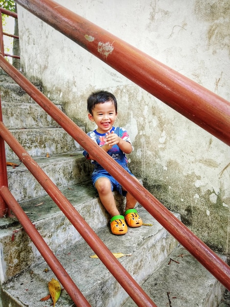 Photo full length of boy sitting on steps