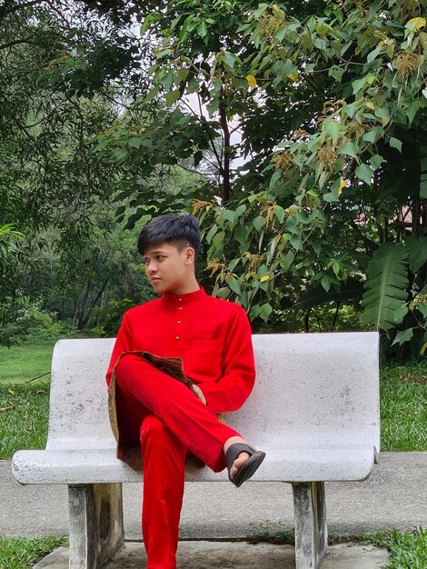 Full length of boy standing on bench against trees