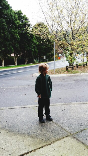 Photo full length of boy standing on sidewalk