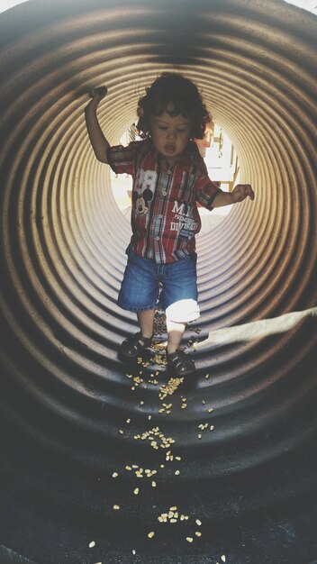 Photo full length of boy in tunnel