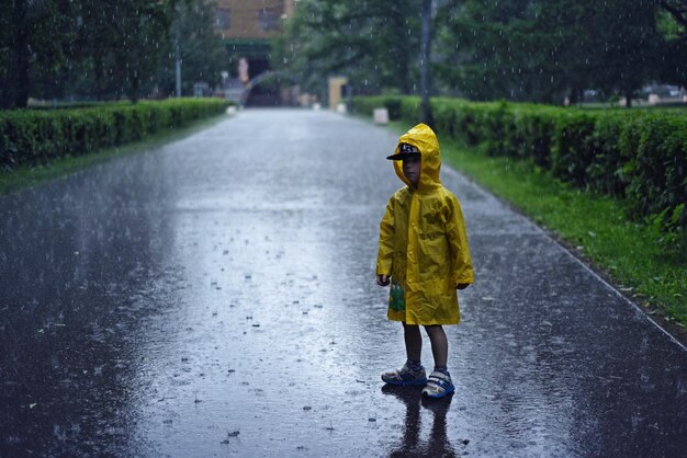 Photo full length of boy in yellow raincoat