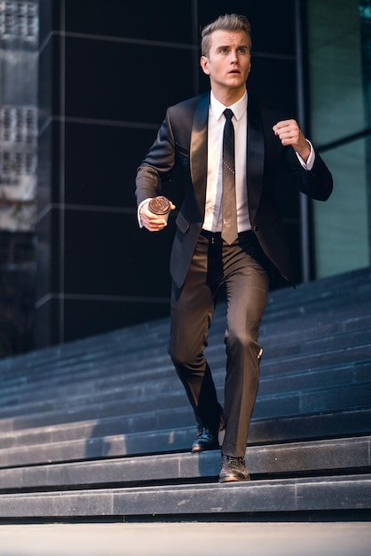 Photo full length of businessman moving down on steps