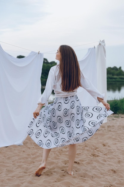 Full length of carefree woman enjoying freedom on sandy beach in summer