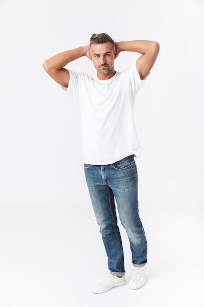 Full length of a casual handsome man wearing t-shirt standing isolated on white, posing