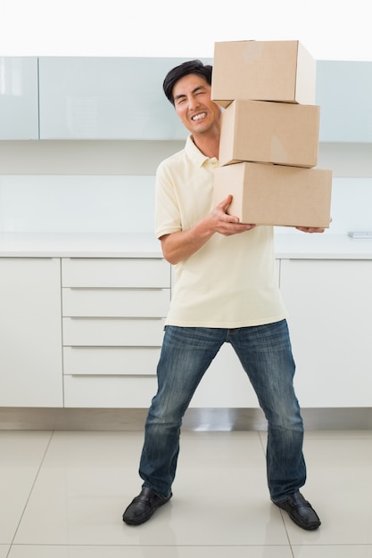 Full length of a casual young man carrying boxes