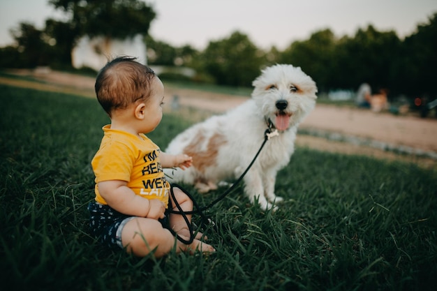 Photo full length of a child and dog on field