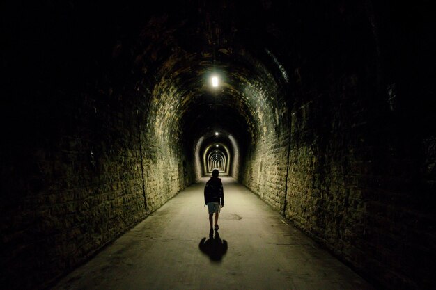 Foto lunghezza intera del bambino nel tunnel illuminato