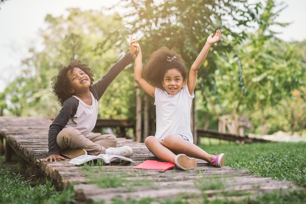 Photo full length of children sitting on wood at park