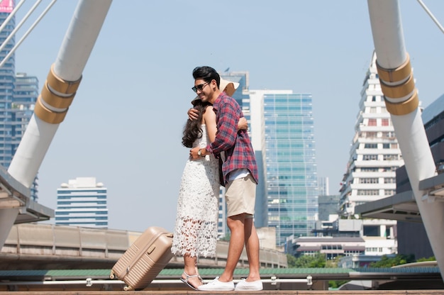 Full length of couple embracing while standing in city against clear sky