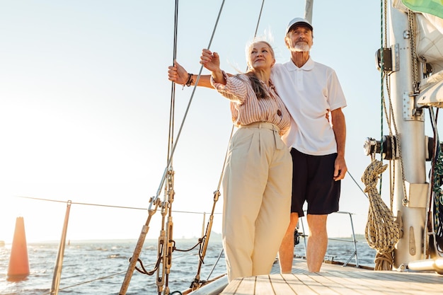 Full length of couple sitting on boat sailing in sea