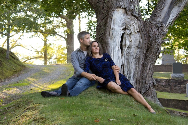 Foto lunghezza completa della coppia seduta sul tronco dell'albero