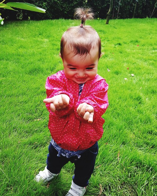 Full length of cute baby girl standing on grass