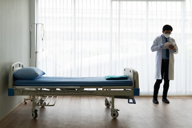 Full length of doctor wearing mask standing at hospital