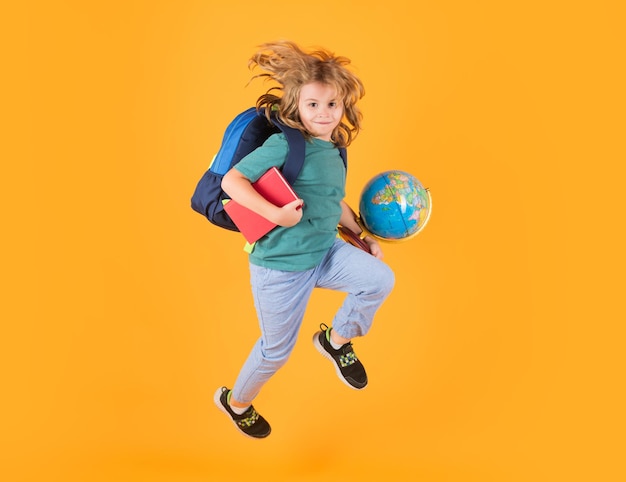Full length of excited kid jumping Back to school School child in school uniform with bagpack