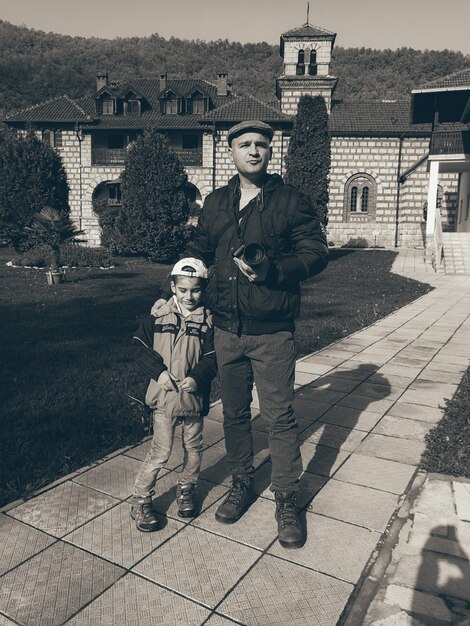 Photo full length of father and son standing on footpath