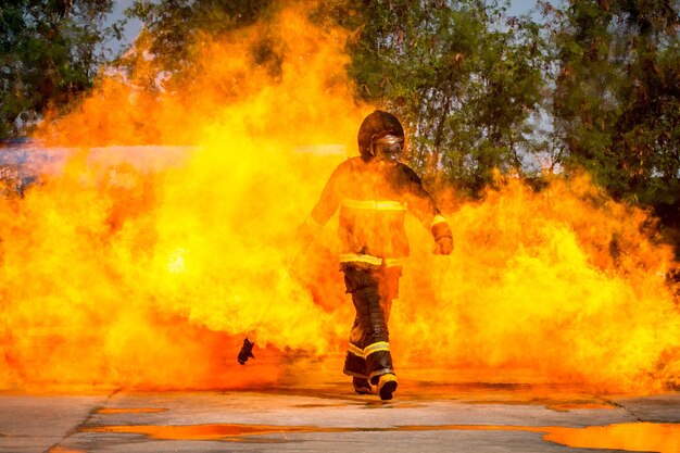 Photo full length of firefighter walking amidst fire