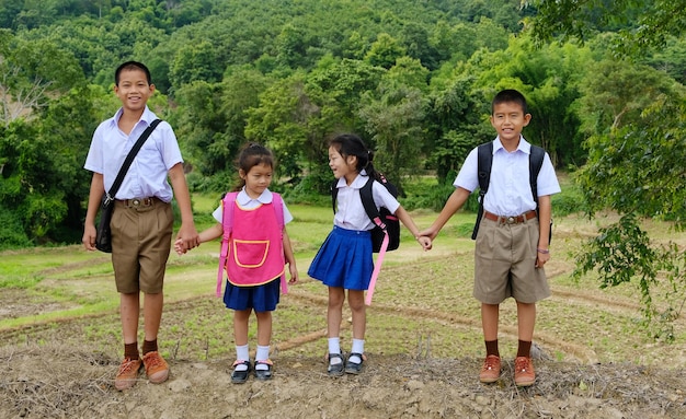 Full length of friends in school uniform standing on field