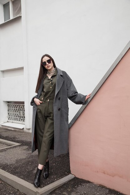 Photo full length front view portrait of young woman in grey coat and suit against wall outdoors outwear