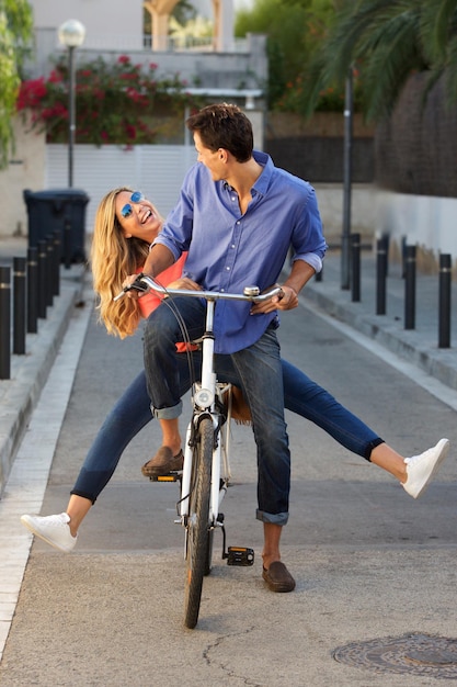 Photo full length fun couple riding bicycle together on path