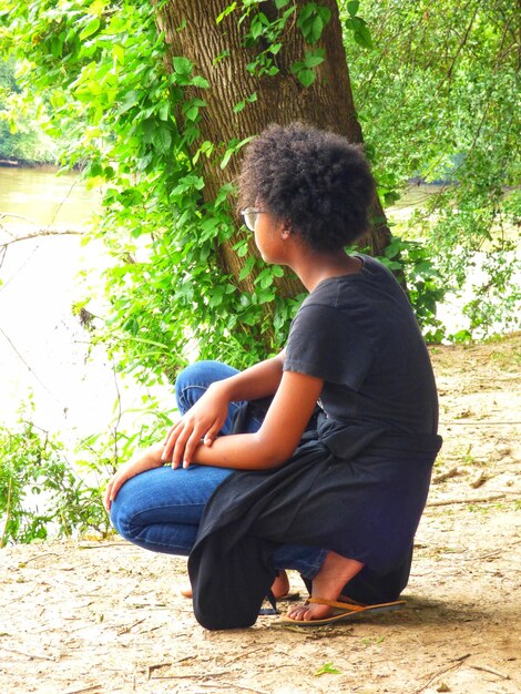 Full length of girl crouching on field