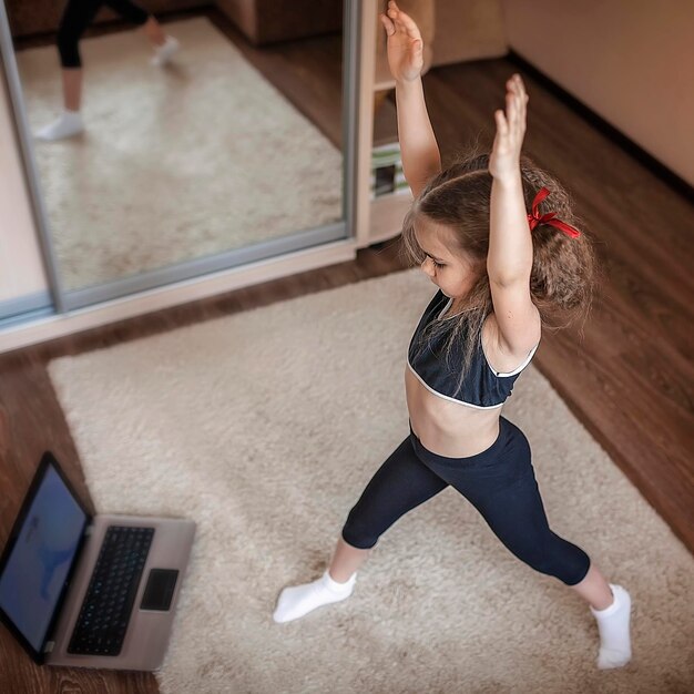 Photo full length of girl exercising at home