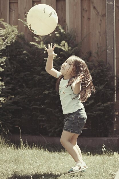 Photo full length of girl holding ball on field