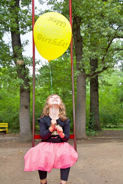 Foto lunghezza completa di una ragazza che tiene i palloncini