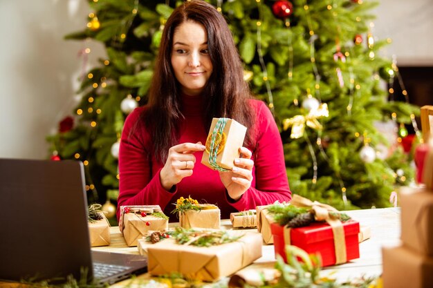 Foto lunghezza completa di una ragazza che tiene l'albero di natale