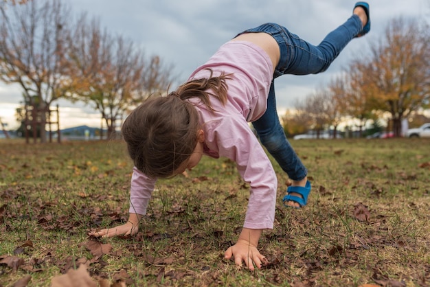 Photo full length of girl practicing handstand on playing field