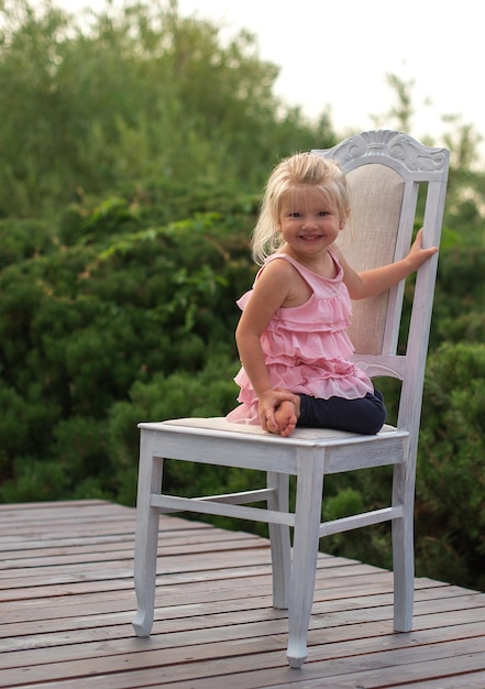 Photo full length of girl sitting on chair at floorboard