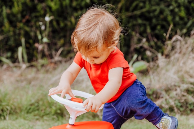 Photo full length of girl sitting on toy car at field