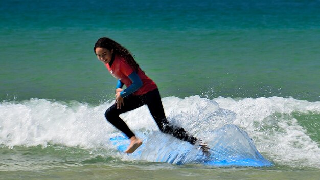 Photo full length of girl surfing in sea