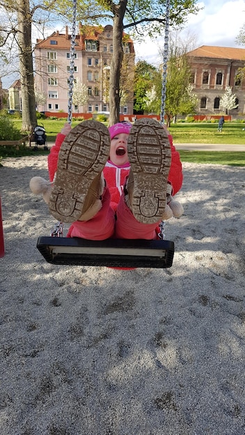 Full length of girl on swing in park