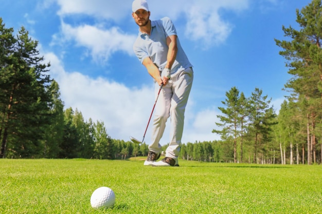 Per tutta la lunghezza del giocatore di golf che gioca a golf in una giornata di sole giocatore di golf maschio professionista che prende colpo sul campo da golf