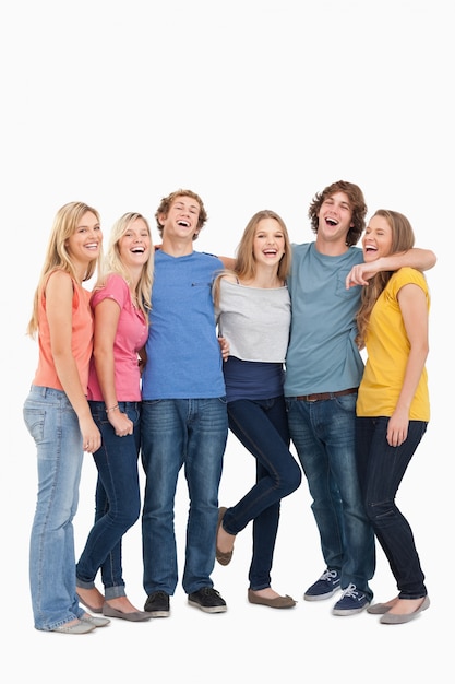 Full length of a group laughing together and looking at the camera 