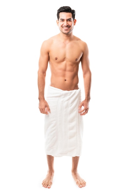 Photo full length of a happy young man standing wearing a towel against white background