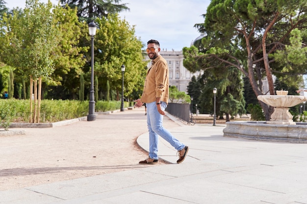 Photo full length happy young man walking in city