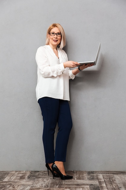 Full length image of Smiling middle-aged woman in elegant clothes