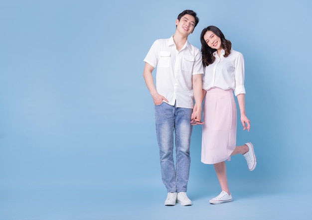 Photo full length image of young asian couple on blue background