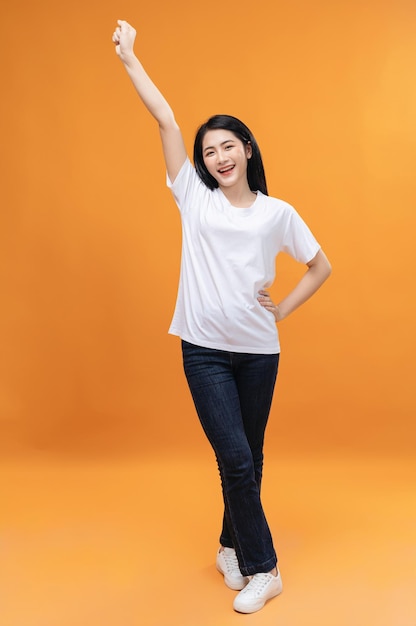 Full length image of young Asian girl on background