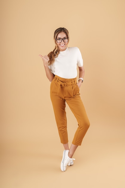 Full length image of young woman wearing eyeglasses smiling isolated