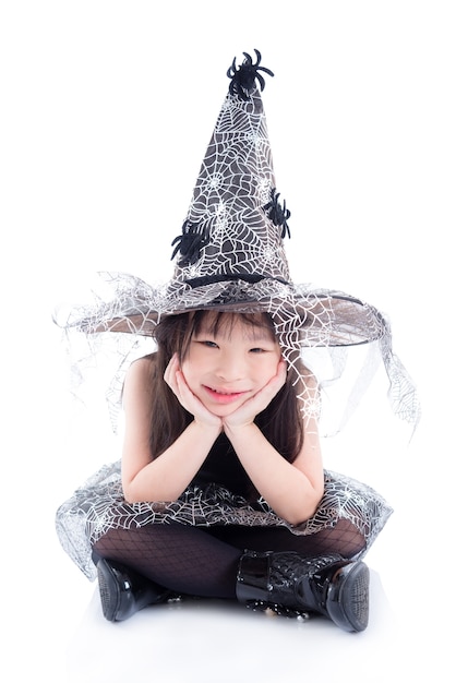 Full length of little asian girl wearing witch costume for Halloween