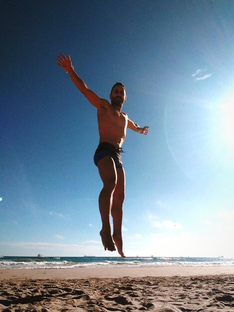 Full length of man on beach against clear sky