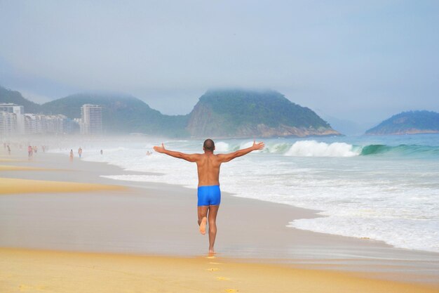 Photo full length of man at beach against sky