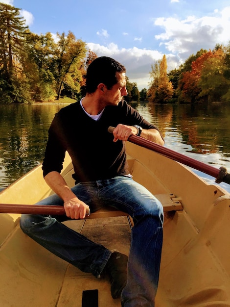 Foto lunghezza completa di un uomo in barca sul lago