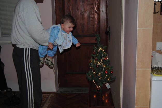 Full length of man in christmas tree at home