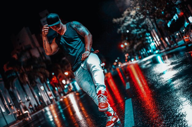 Photo full length of man dancing on road in city at night