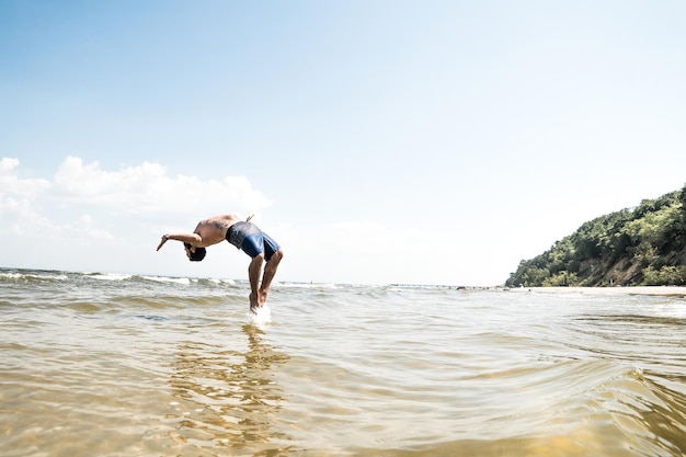 Full length of man diving in sea against sky