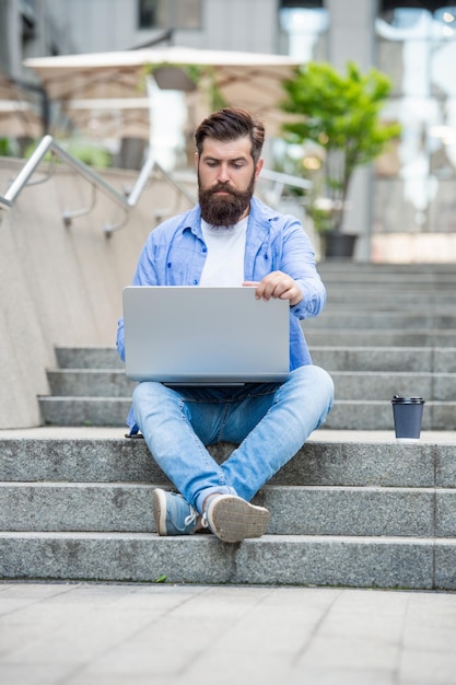 Full length of man freelancer has video call outside man freelancer has video call at coffee break man freelancer has video call outdoor man freelancer has video call on laptop